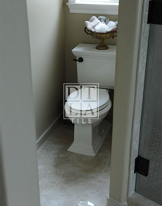 View of new toilet porcelain tile in Manhattan Beach with tile baseboard moulding