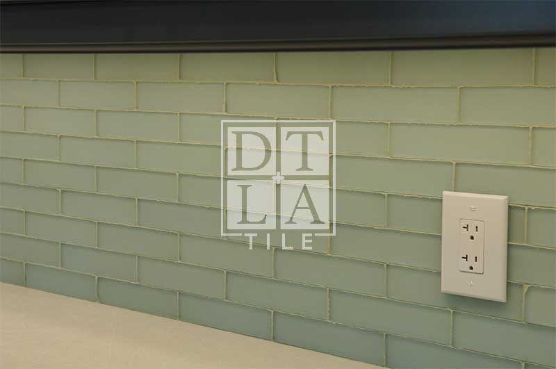 Kitchen backsplash with glass tile and electrical outlet